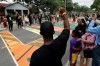 People raise their arms in solidarity as Sierra Davis Sanders and Ericka Still perform during a Juneteenth 2020 celebration outside the Dr. Carter G. Woodson African American Museum Friday, June 19, 2020, in St. Petersburg, Fla. Juneteenth marks the day in 1865 when federal troops arrived in Galveston, Texas to take control of the state and ensure all enslaved people be freed. (AP Photo/Chris O'Meara)
