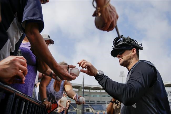 New York Yankees manager Aaron Boone signs autographs during a spring training baseball workout Thursday, Feb. 13, 2020, in Tampa, Fla. (AP Photo/Frank Franklin II)