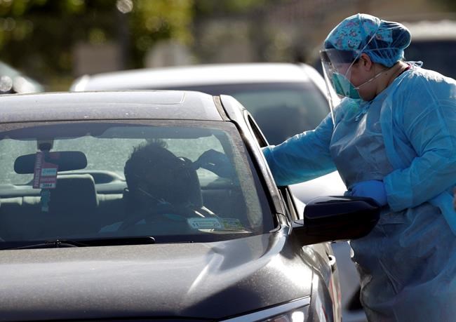 A man is swabbed as he is tested for COVID-19 as vehicles line up at the Doris Ison Health Center, Wednesday, March 18, 2020, in Miami. The testing is being provided by Community Health of South Florida, Inc. According to the World Health Organization, most people recover in about two to six weeks, depending on the severity of the illness. (AP Photo/Lynne Sladky)