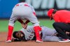 Los Angeles Angels manager Joe Maddon, top, leans over to check on Dexter Fowler who was injured during a play at second base against the Toronto Blue Jays during the second inning of a baseball game Friday, April 9, 2021, in Dunedin, Fla. (AP Photo/Mike Carlson)