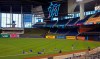 New York Mets players sit on the field before a baseball game against the Miami Marlins, Thursday, Aug. 20, 2020, in Miami. Major League Baseball says the Mets have received two positive tests for COVID-19 in their organization, prompting the postponement of two games against the Marlins. (David Santiago/Miami Herald via AP)