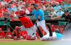 Miami Marlins' Jonathan Villar, bottom right, slides into home to score in the first inning of a baseball game against the St. Louis Cardinals in Jupiter, Fla., Monday, Feb. 24, 2020. (Charles Trainor Jr./Miami Herald via AP)