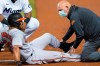Baltimore Orioles' Anthony Santander (25) is assisted by a trainer after he was injured during the first inning of a baseball game against the Miami Marlins, Tuesday, April 20, 2021, in Miami. (AP Photo/Marta Lavandier)