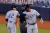 Tampa Bay Rays' Willy Adames, left, is congratulated by first base coach Ozzie Timmons after getting a base hit during the first inning of a baseball game against the Miami Marlins, Sunday, Aug. 30, 2020, in Miami. (AP Photo/Wilfredo Lee)