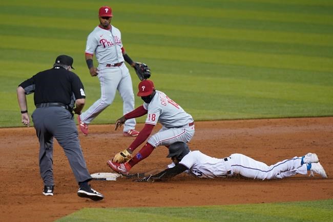 Philadelphia Phillies shortstop Didi Gregorius (18) attempts to tag out Miami Marlins' Starling Marte who advances to second base after Jesus Aguilar flew out during the third inning of a baseball game, Thursday, Sept. 10, 2020, in Miami. (AP Photo/Wilfredo Lee)