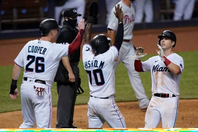 Miami Marlins' Garrett Cooper (26), Jazz Chisholm (70) and Corey Dickerson, right, celebrate after they scored on a double by Starling Marte during the eighth inning of a baseball game against the Philadelphia Phillies, Thursday, Sept. 10, 2020, in Miami. (AP Photo/Wilfredo Lee)