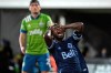 Vancouver Whitecaps midfielder Leonard Owusu reacts after missing a shot on goal as Seattle Sounders defender Shane O'Neill, left, watches during the first half of an MLS soccer match, Sunday, July 19, 2020, in Kissimmee, Fla. (AP Photo/Phelan M. Ebenhack)