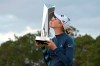 Jessica Korda kisses the championship trophy on the 18th green after winning in a one-hole playoff against Danielle Kang during the final round of the Tournament of Champions LPGA golf tournament, Sunday, Jan. 24, 2021, in Lake Buena Vista, Fla. (AP Photo/Phelan M. Ebenhack)
