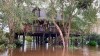 A woman stands on her deck as flood water surrounds her home, Thursday, Sept. 17, 2020 in East Milton, Fla. Rescuers with high-water vehicles have been rescuing people on the Gulf Coast cut off by floodwaters after Hurricane Sally. Crews were pulling people out of flooded areas Thursday near Pensacola , Florida, while Alabama National Guard troops helped people evacuate near Mobile Bay. (Annie Blanks/Pensacola News Journal via AP)