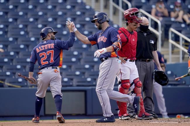 Houston Astros' Steven Souza Jr., center, is congratulated by teammate Jose Altuve, left, as Washington Nationals catcher Tres Barrera, right, stands by after Souza hit a two-run home run during the fourth inning of a spring training baseball game Monday, March 1, 2021, in West Palm Beach, Fla. (AP Photo/Jeff Roberson)