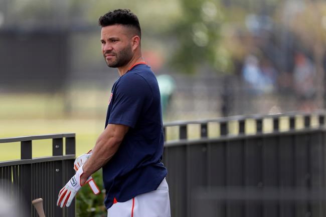 Houston Astros infielder Jose Altuve puts on batting gloves during spring training baseball practice Thursday, Feb. 13, 2020, in West Palm Beach, Fla. (AP Photo/Jeff Roberson)