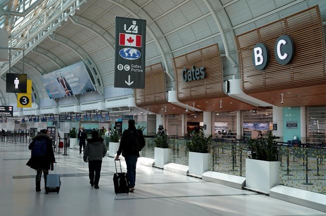 Travellers walk through Terminal 3 at Pearson International Airport in Toronto, Friday, March 13, 2020. Provincial governments have advised against international travel and Ontario announced plans to close its schools for two weeks because of COVID-19.THE CANADIAN PRESS/Frank Gunn