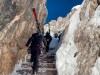 Skiers make their way to reach the start of the men's downhill course, at the alpine ski World Championships in Cortina d'Ampezzo, Italy, Friday, Feb. 12, 2021. To reach the start of the new men's downhill course in Cortina, skiers have to climb 223 steps at an altitude of 2,400 meters (8,000 feet). The course's name, Vertigine, translates to 