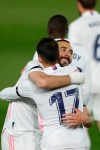 Real Madrid's Karim Benzema, left, celebrates with teammate Lucas Vazquez after scoring the opening goal during the Spanish La Liga soccer match between Real Madrid and FC Barcelona at the Alfredo di Stefano stadium in Madrid, Spain, Saturday, April 10, 2021. (AP Photo/Manu Fernandez)