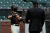 San Francisco Giants ball kid Austin Ginn, left, brings balls to umpire Brian Knight during the first inning of an exhibition baseball game between the Oakland Athletics and the Giants in San Francisco, Tuesday, July 21, 2020. (AP Photo/Jeff Chiu)
