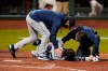Seattle Mariners manager Scott Servais, left, and a trainer check on Dylan Moore after he was hit by a pitch from San Francisco Giants' Sam Coonrod during the seventh inning of a baseball game in San Francisco, Wednesday, Sept. 16, 2020. (AP Photo/Jeff Chiu)