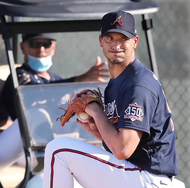 Atlanta Braves manager Brian Snitker, left, sits in a golf cart watching pitcher Charlie Morton get in some work during a morning pitching session on the practice mounds during baseball spring training at CoolToday Park in North Port, Fla., Friday, Feb. 26, 2021. (Curtis Compton/Atlanta Journal-Constitution via AP)