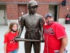 Atlanta Braves fans Pete Ciccarello and his daughter Haley pause for a photo with the statue of Jackie Robinson on Jackie Robinson Day prior to a baseball game between the Miami Marlins and Atlanta Braves in Atlanta, Thursday, April 15, 2021. (Curtis Compton/Atlanta Journal-Constitution via AP)
