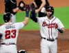 Atlanta Braves' Dansby Swanson gets a high-five from Adam Duvall after hitting a home run during the second inning in Game 2 of a baseball National League Division Series against the Miami Marlins Wednesday, Oct. 2020, in Houston. (Curtis Compton/Atlanta Journal-Constitution via AP)