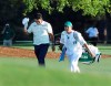 Hideki Matsuyama, of Japan, tips his cap as he walks to the 18th green with caddie Shota Hayafuji at the Masters golf tournament in Augusta, Ga., Sunday, April 11, 2021. A decade after Matsuyama made a sterling debut as the best amateur at Augusta National, he claimed the ultimate trophy with a victory in the Masters. (Curtis Compton/Atlanta Journal-Constitution via AP)