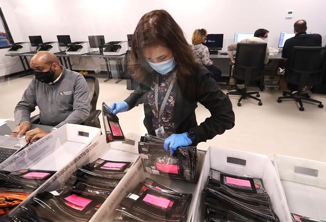 Election workers tabulate ballots at the Beauty P. Baldwin Voter Registrations and Elections Building, Tuesday, Jan. 5, 2021, in Lawrenceville, Ga. (Curtis Compton/Atlanta Journal-Constitution via AP)