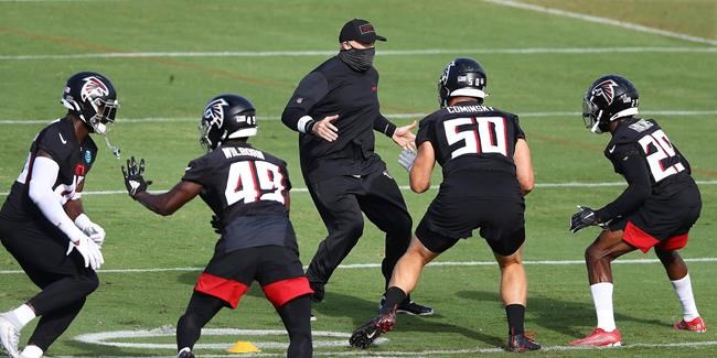 Atlanta Falcons head coach Dan Quinn, center rear, demonstrates a defensive drill during an NFL football training camp practice in Flowery Branch, Ga., Thursday, Aug. 27, 2020. (Curtis Compton/Atlanta Journal-Constitution via AP, Pool)