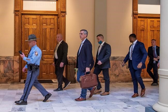 Lead by a Georgia State Trooper, Georgia Secretary of State Brad Raffensperger, center, exits the Georgia State Capitol building after hearing reports of threats, Wednesday, Jan. 6, 2021, in Atlanta. (Alyssa Pointer/Atlanta Journal-Constitution via AP)