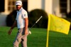 Dustin Johnson looks over his shot on the 18th green next to the Masters yellow flag during the third round of the Masters golf tournament Saturday, Nov. 14, 2020, in Augusta, Ga. (Curtis Compton/Atlanta Journal-Constitution via AP)