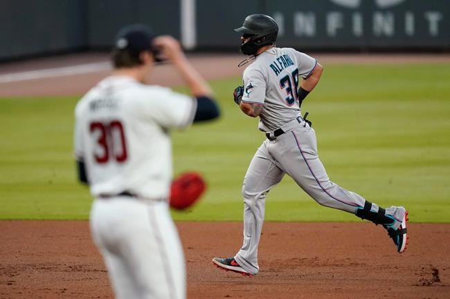 Miami Marlins' Jorge Alfaro (38) runs past Atlanta Braves pitcher Kyle Wright as he runs the bases after hitting a solo home run during the third inning of a baseball game Tuesday, Sept. 8, 2020, in Atlanta. (AP Photo/Brynn Anderson)