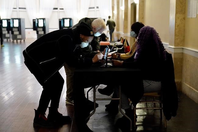 Voters register before casting their vote during Georgia's Senate runoff elections on Tuesday, Jan. 5, 2021, in Atlanta. (AP Photo/Brynn Anderson)