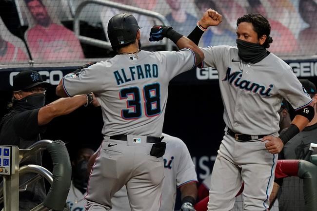 Miami Marlins' Jorge Alfaro, left, celebrates with Miguel Rojas, right, after Alfaro hits a home run during the third inning of the team's baseball game against the Atlanta Braves on Tuesday, Sept. 8, 2020, in Atlanta. (AP Photo/Brynn Anderson)