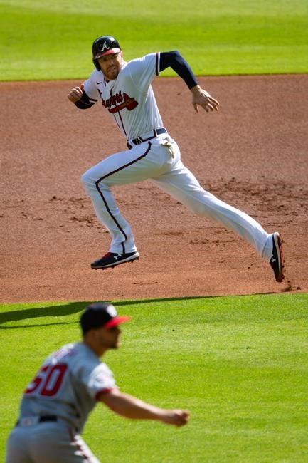Atlanta Braves' Freddie Freeman, top, steals second base on a pitch by Washington Nationals pitcher Austin Voth (50) during the first inning of the first game in a doubleheader baseball game Friday, Sept. 4, 2020, in Atlanta. (AP Photo/John Amis)