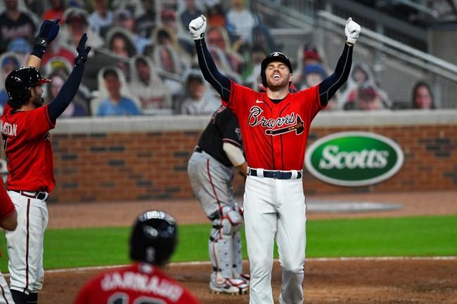 Atlanta Braves' Freddie Freeman reacts as he crosses home plate during a grand slam to center field during the fourth inning of the second baseball game of a doubleheader against the Washington Nationals, Friday, Sept. 4, 2020, in Atlanta. (AP Photo/John Amis)