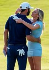 Dustin Johnson celebrates with his partner Paulina Gretzky on the 18th green after winning the Tour Championship golf tournament and FedEx Cup on Monday, Sept. 7, 2020 at East Lake Golf Club in Atlanta. (AP Photo/John Bazemore)