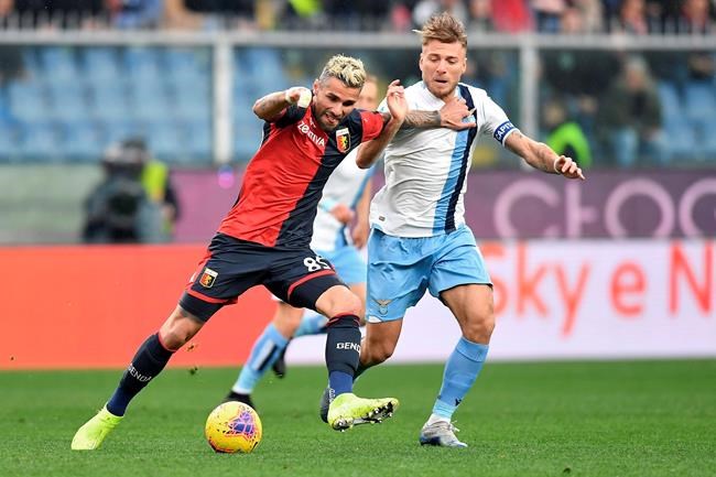 Lazio's Ciro Immobile, is challenged by Genoa's Valon Behrami, left, during the Serie A soccer match between Genoa and Lazio, at the Luigi Ferrari stadium in Genoa, Italy, Sunday, Feb. 23, 2020. (Tano Pecoraro/Lapresse via AP)