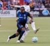 Montreal Impact's Zachary Brault-Guillard, left, challenges New England Revolution's Teal Bunbury during second half MLS soccer action in Montreal, Saturday, February 29, 2020. THE CANADIAN PRESS/Graham Hughes