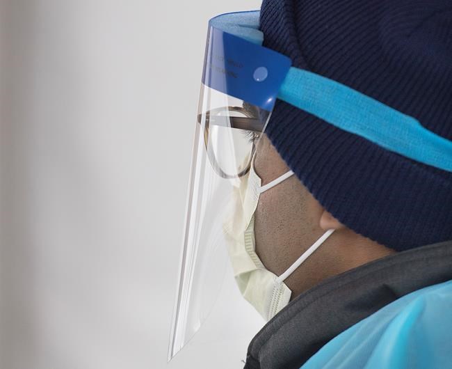 A healthcare worker looks on at a drive-thru COVID-19 test clinic in Montreal, Sunday, March 29, 2020, as Coronavirus COVID-19 cases rise in Canada and around the world. THE CANADIAN PRESS/Graham Hughes