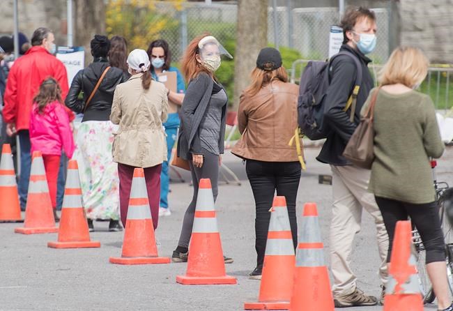 People wait to be tested for COVID-19 at a mobile clinic in Montreal, Sunday, May 17, 2020, as the COVID-19 pandemic continues in Canada and around the world. THE CANADIAN PRESS/Graham Hughes