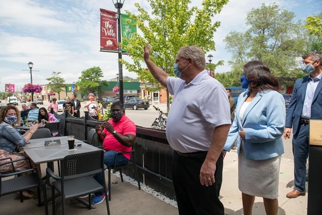 Ontario Premier Doug Ford waves to customers at Cuchulainn's Irish Pub in Mississauga, Ont., on Tuesday, July 21, 2020. THE CANADIAN PRESS/Galit Rodan