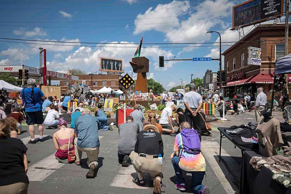 People take a knee during a moment of silence on the one year anniversary of George Floyd's death on Tuesday, May 25, 2021, in Minneapolis, Minn. (AP Photo/Christian Monterrosa)