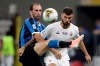 Inter Milan's Diego Godin, left, fights for the ball with Fiorentina's Patrick Cutrone during a Serie A soccer match between Inter Milan and Fiorentina, at the San Siro stadium in Milan, Italy, Wednesday, July 22, 2020. (AP Photo/Luca Bruno)