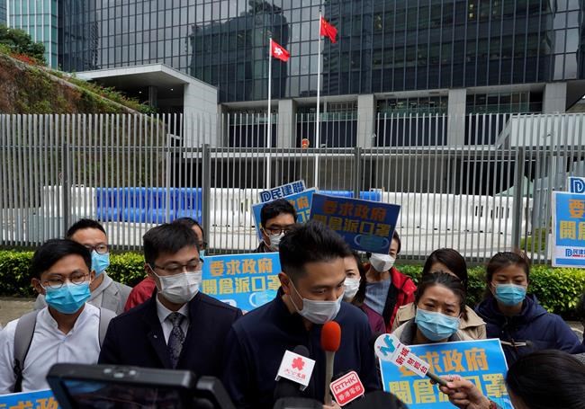 Pro-China supporters wearing masks urge government to deliver masks to local people during a protest in Hong Kong, Tuesday, Feb. 4, 2020. Hong Kong on Tuesday reported its first death from a new virus, a man who had traveled from the mainland city of Wuhan that has been the epicenter of the outbreak. (AP Photo/Vincent Yu)
