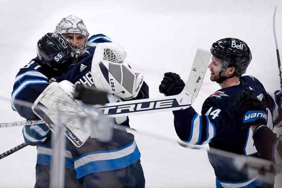 CPWinnipeg Jets' Mark Scheifele (55) celebrates his game-winning goal in overtime against the Arizona Coyotes with goaltender Connor Hellebuyck (37) and Josh Morrissey (44) during NHL action in Winnipeg on Sunday March 27, 2022. (Fred Greenslade / The Canadian Press)