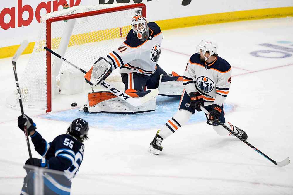 Mark Scheifele scores on goaltender Mike Smith during the first period Monday. (Fred Greenslade / The Canadian Press)