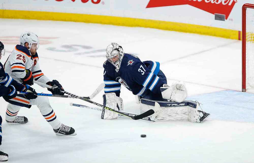 CP
Winnipeg Jets goaltender Connor Hellebuyck (37) prepares to make a save on Edmonton Oilers' Leon Draisaitl (29) as Jets' Josh Morrissey (44) defends during the third period. (John Woods / The Canadian Press)