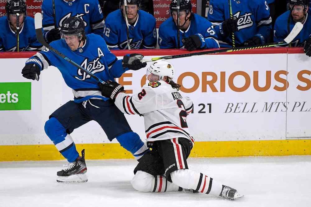 Winnipeg Jets' Mark Scheifele (55) and Chicago Blackhawks' Duncan Keith (2) battle along the boards during the first period.(Fred Greenslade / The Canadian Press)