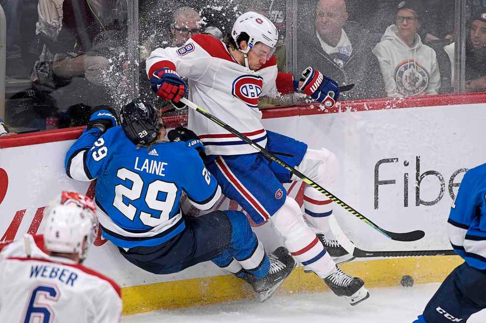 Patrik Laine is hit by former teammate Ben Chiarot in the third period. (Fred Greenslade / The Canadian Press)