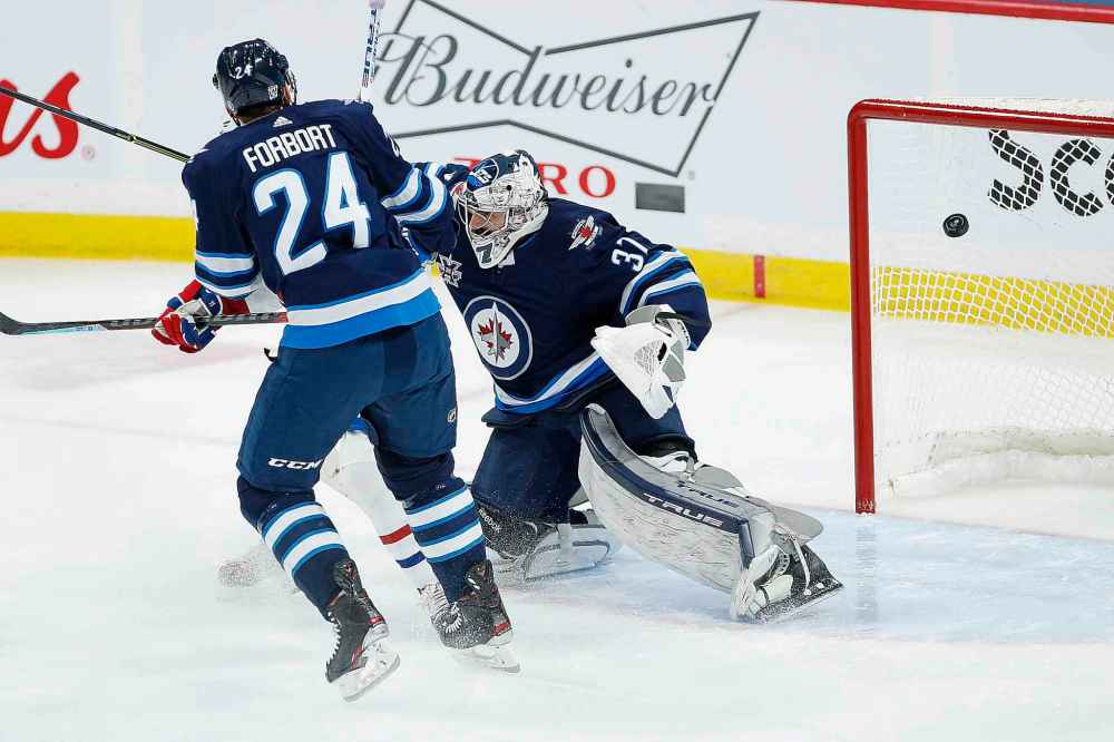Montreal Canadiens' Brendan Gallagher's (11) deflection goes off the crossbar behind Winnipeg Jets goaltender Connor Hellebuyck (37) as Derek Forbort (24) defends during the first period. (John Woods / The Canadian Press)