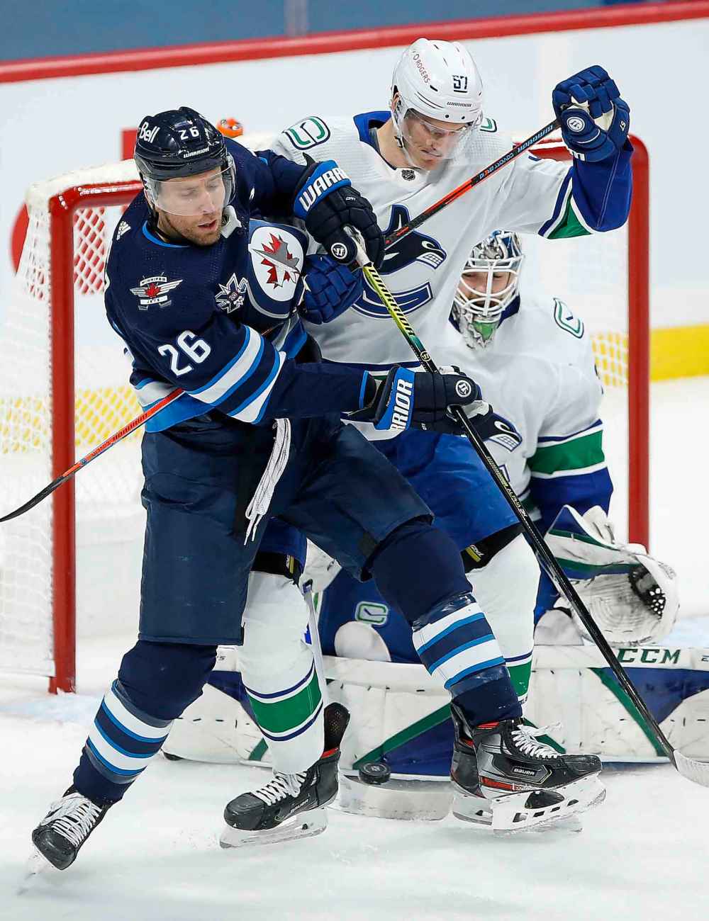 Winnipeg Jets' Blake Wheeler (26) attempts the deflection as Vancouver Canucks' Tyler Myers (57) defends for goaltender Thatcher Demko (35) during the first period. (John Woods / The Canadian Press)