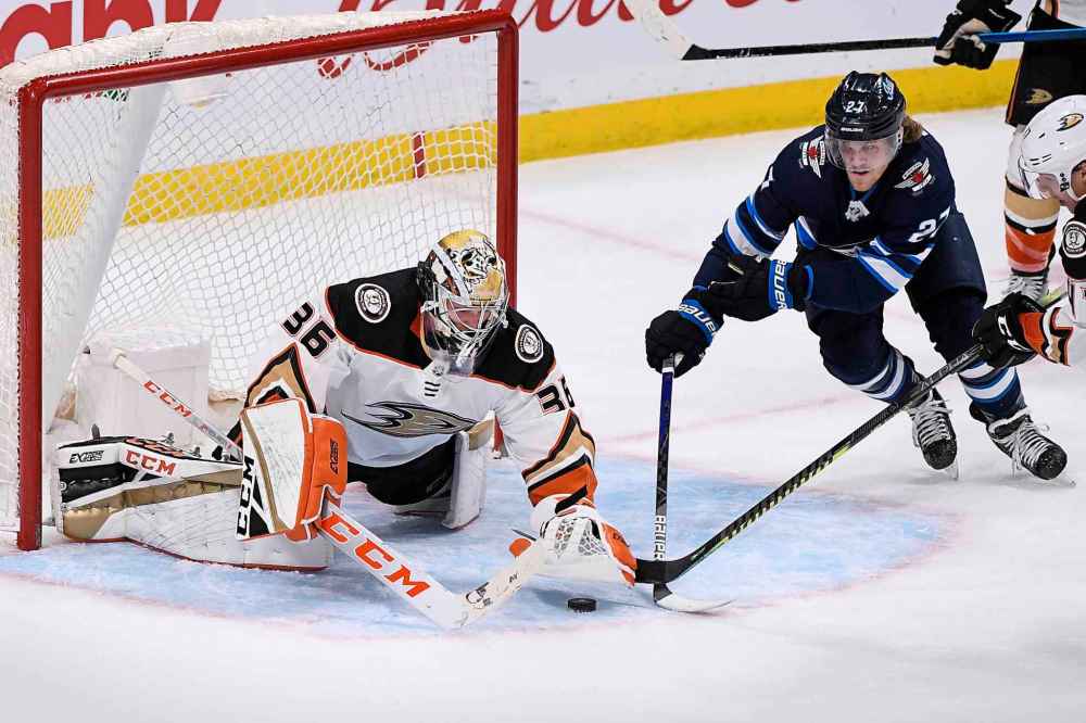 FRED GREENSLADE / THE CANADIAN PRESS
Anaheim Ducks goaltender John Gibson (36) covers up the puck as Winnipeg Jets' Nikolaj Ehlers (27) looks for the rebound during third period NHL action in Winnipeg on Sunday, Dec. 8, 2019./p